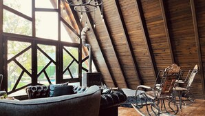 A cozy room with a wooden ceiling, a fireplace, a rocking chair, and a sofa. -  Otelox Sinap Bungalow  (Erdemli)