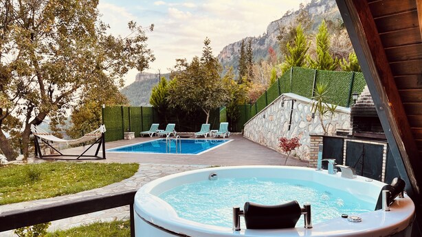 A hot tub and a swimming pool in a backyard with a view of mountains. -  Otelox Sinap Bungalow  (Erdemli)