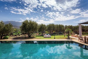 A clear swimming pool with a view of mountains and trees in the background. - Atlas Luxury Garden (Ouirgane)