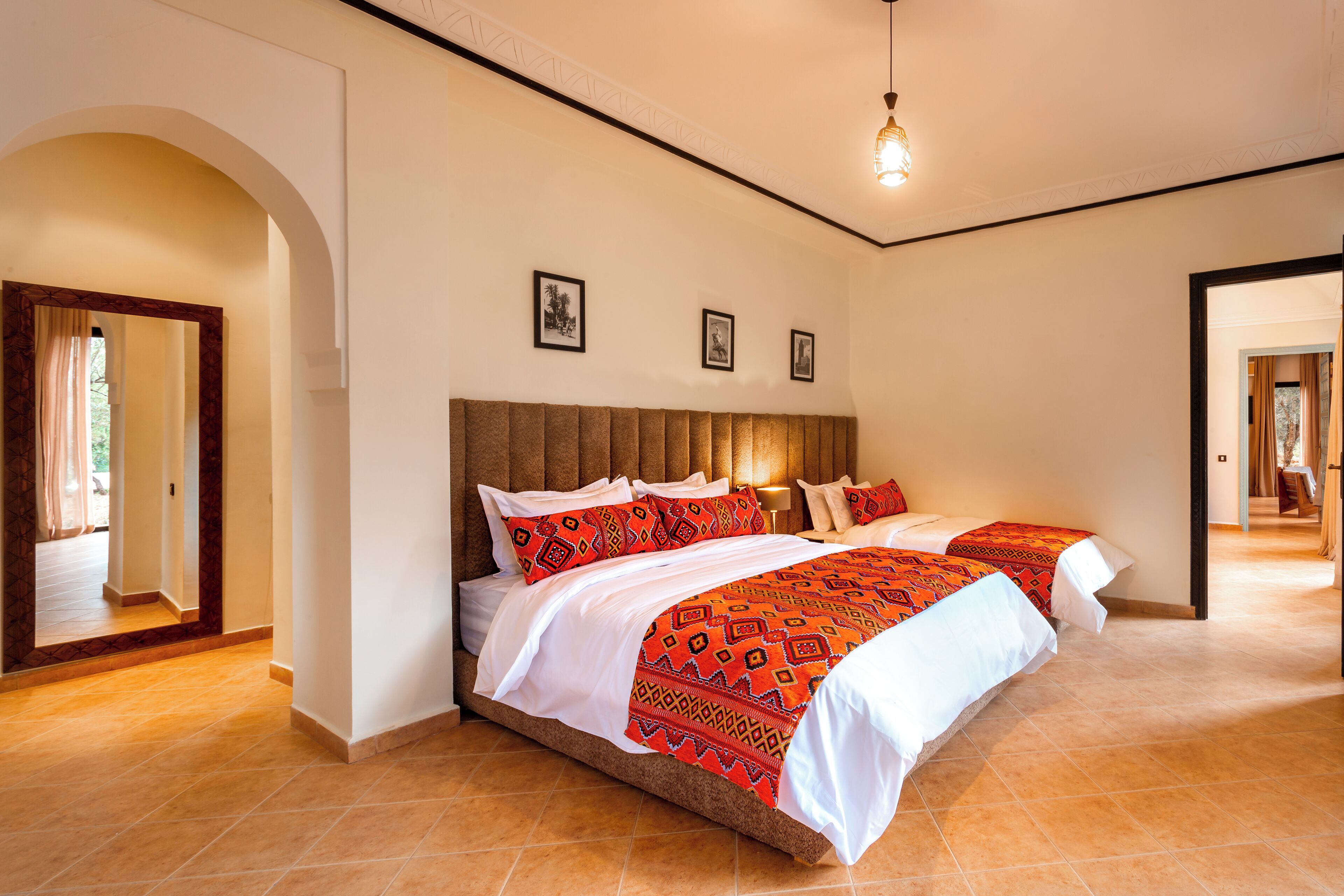 A hotel room with a large bed, a wooden headboard, and a view of the hallway.