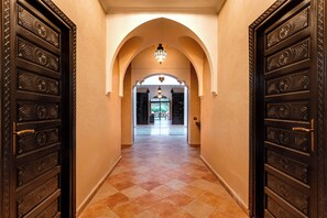 A hallway with ornate doors, a tiled floor, and an arched ceiling. - Atlas Luxury Garden (Ouirgane)