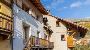 Un immeuble à plusieurs étages, doté de balcons en bois et d’une façade rustique.