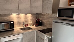 Ett modernt kök med inbyggd mikrovågsugn, kaffebryggare och diskmaskin.