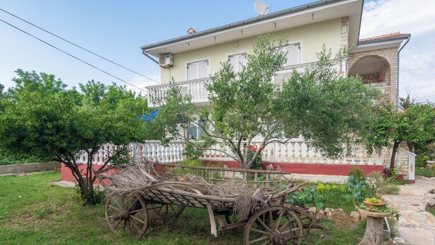 A traditional wooden cart in a garden with a house in the background. - Apartment Basic Mario (Vir)