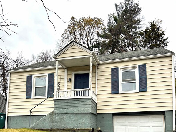 A two-story house with a front porch, a garage, and a small balcony.