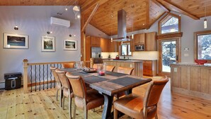Un interior de madera con una mesa de comedor, sillas y zona de cocina.