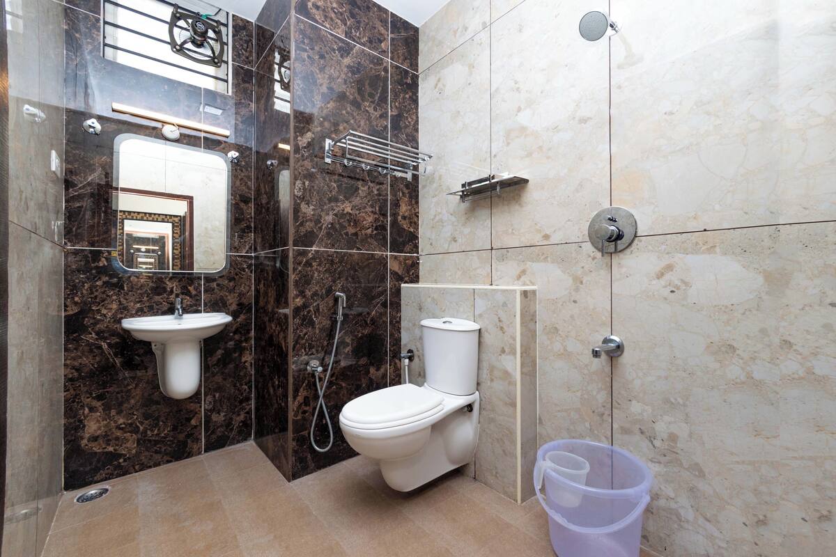 Un baño moderno con lavamanos, inodoro y ducha de mármol.