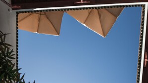 A building with a large arched window and a wooden balcony. - Le Singe Rose (Marrakech)