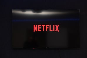 A flat-screen TV with the Netflix logo on a dark wall. - Nottingham 5-br, Sleeps 11 w/ Garden & Parking (Nottingham)