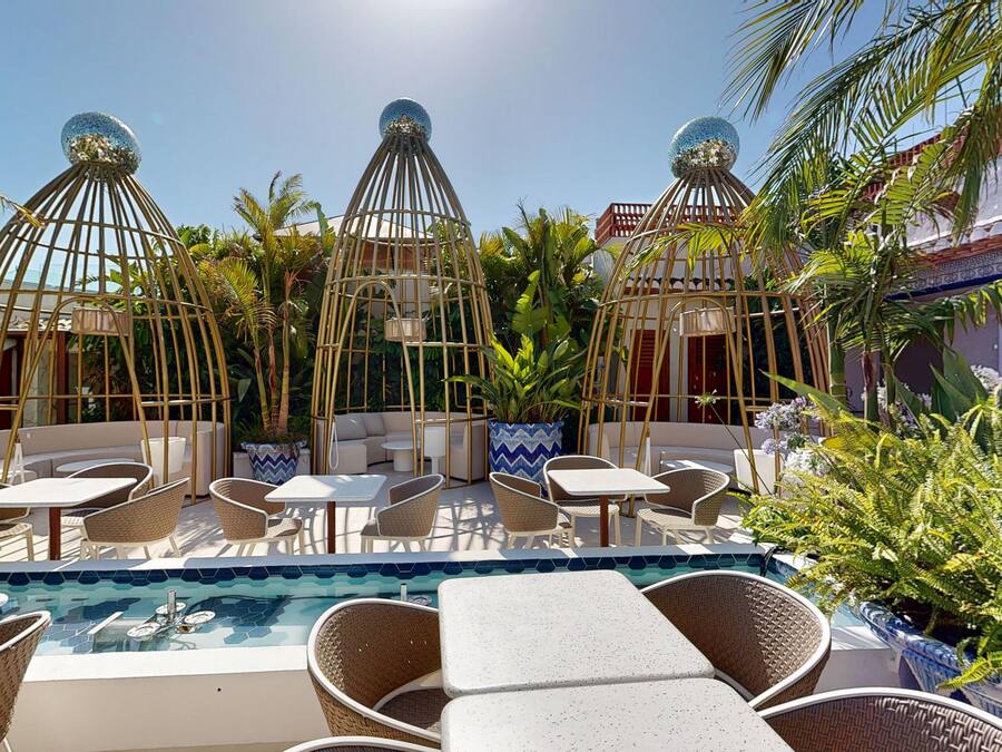 Un área junto a la piscina con sillones de descanso, una piscina pequeña y estructuras esféricas decorativas.