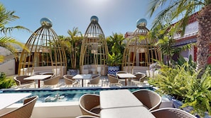 A poolside area with lounge chairs, a small pool, and decorative spherical structures. - Nomada House by SH Hoteles  (Denia)