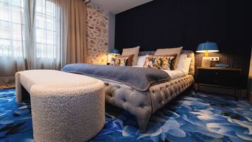 A bedroom with a bed, nightstands, a lamp, and a window with curtains.