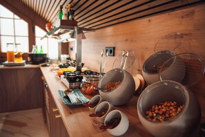 A kitchen counter with various food items and containers, including bowls and jars, in a wooden interior setting. - Nomada House by SH Hoteles  (Denia)