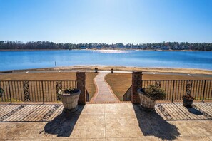 A patio with a view of a lake, a paved walkway, and two planters. - Lakefront Family Retreat with Game Room Fun (Sanford)
