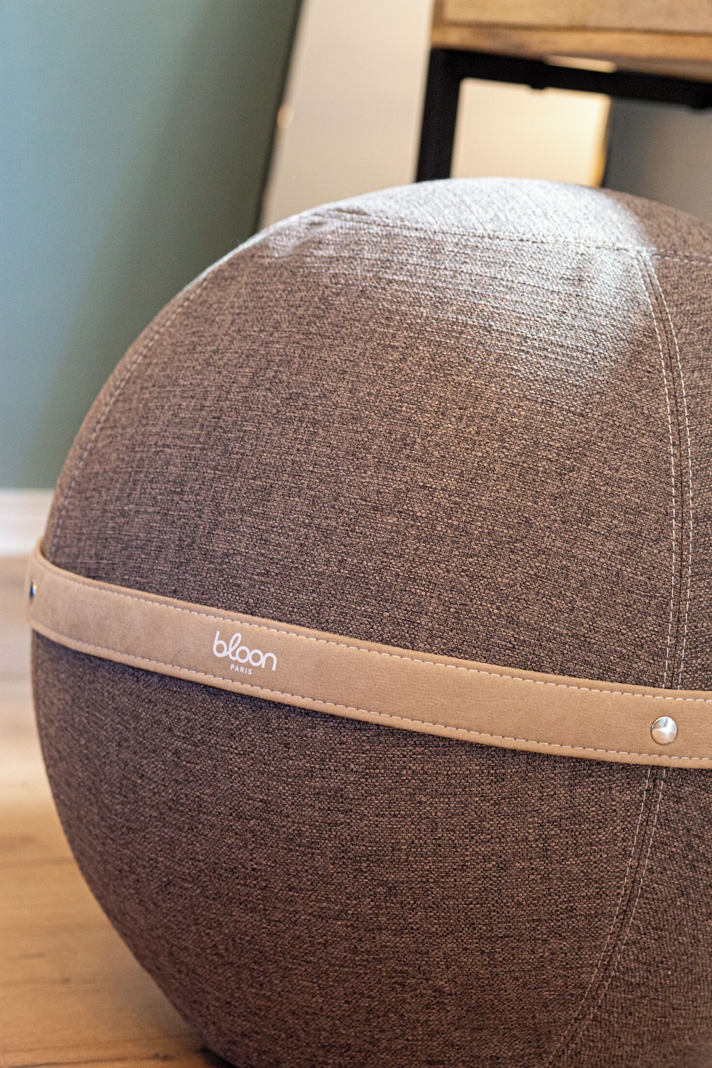 A brown, textured object with a leather band labeled "bloom paris."