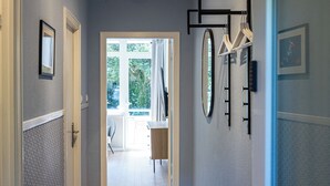 A hallway with a bench, a door, and a view of an outdoor area with a chair and a table. - have-a-nice-stay - modern, near train station, quiet, 15 minutes by train to HH (Ahrensburg)