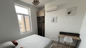 A bedroom with a bed, a desk, and a window. - Amiens, l'appartement douillet 2-4P (Amiens)
