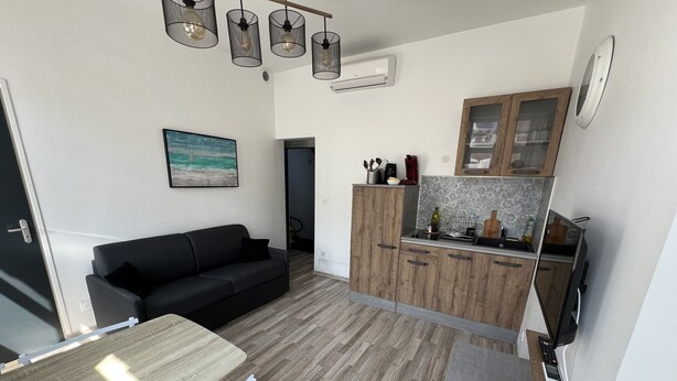 A compact living space with a sofa, dining table, and kitchenette. - Amiens, l'appartement douillet 2-4P (Amiens)
