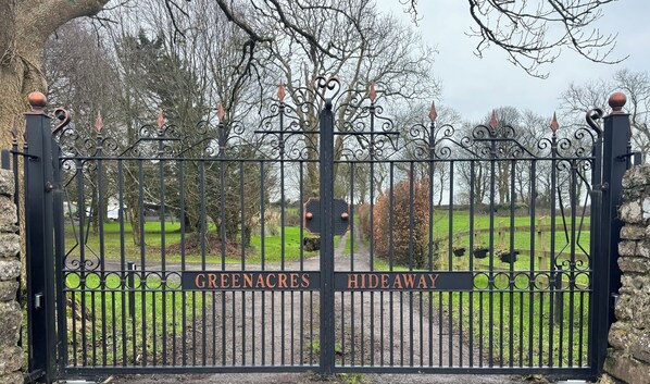 A wrought iron gate with the words "GREENACRES HIDEAWAY" engraved on it. - Hideaway Cottages - Greenacres Estates (Tenby)