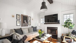 A modern living room with a sofa, coffee table, and fireplace. - Ready Aim (Atlanta)