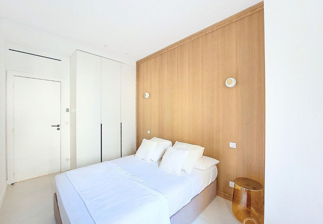 Een slaapkamer met een bed, een kledingkast en een nachtkastje.
