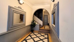 A hallway with a tiled floor, a staircase, and a door at the end. - N&J - PALMIERS TERRASSE - Central - Terrace (Niza)