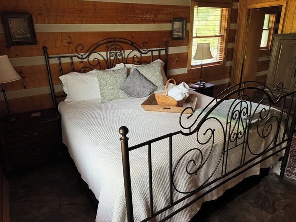 A bed with a metal frame, white bedding, and pillows. There is a basket with bread on the bed. - Harpeth Moon Summary: (Kingston Springs)