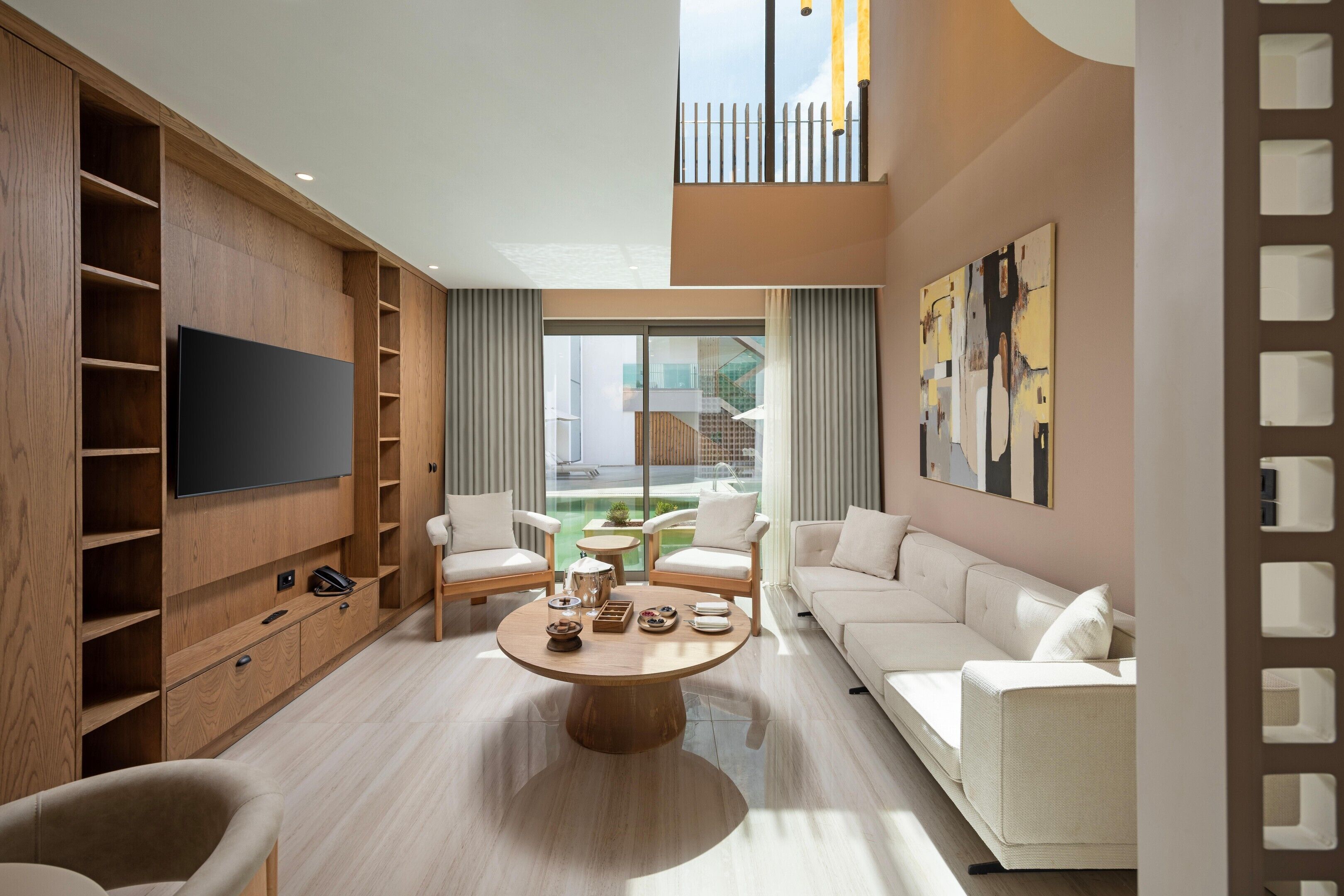Ein modernes Wohnzimmer mit Flachbildfernseher, Holzbögen, einem runden Couchtisch und einer Couch.
