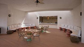 Ein geräumiges Zimmer mit gewölbter Decke, Deckenventilator, Bar mit Flaschenregalen und einer Sitzecke mit Korbstühlen und einer Couch.