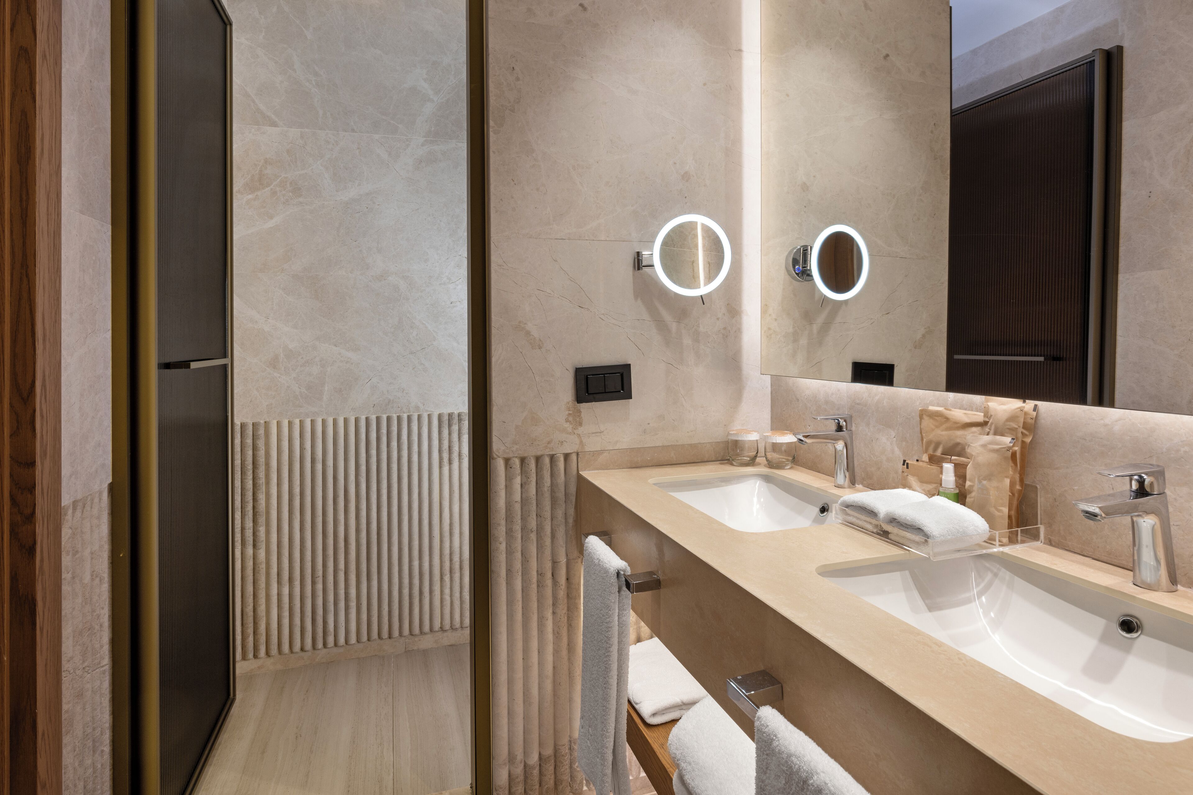 Ein modernes Badezimmer mit zwei Waschbecken, einem Spiegel und einem Handtuchhalter.