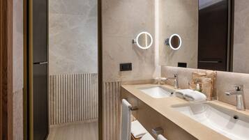 Ein modernes Badezimmer mit zwei Waschbecken, einem Spiegel und einem Handtuchhalter.