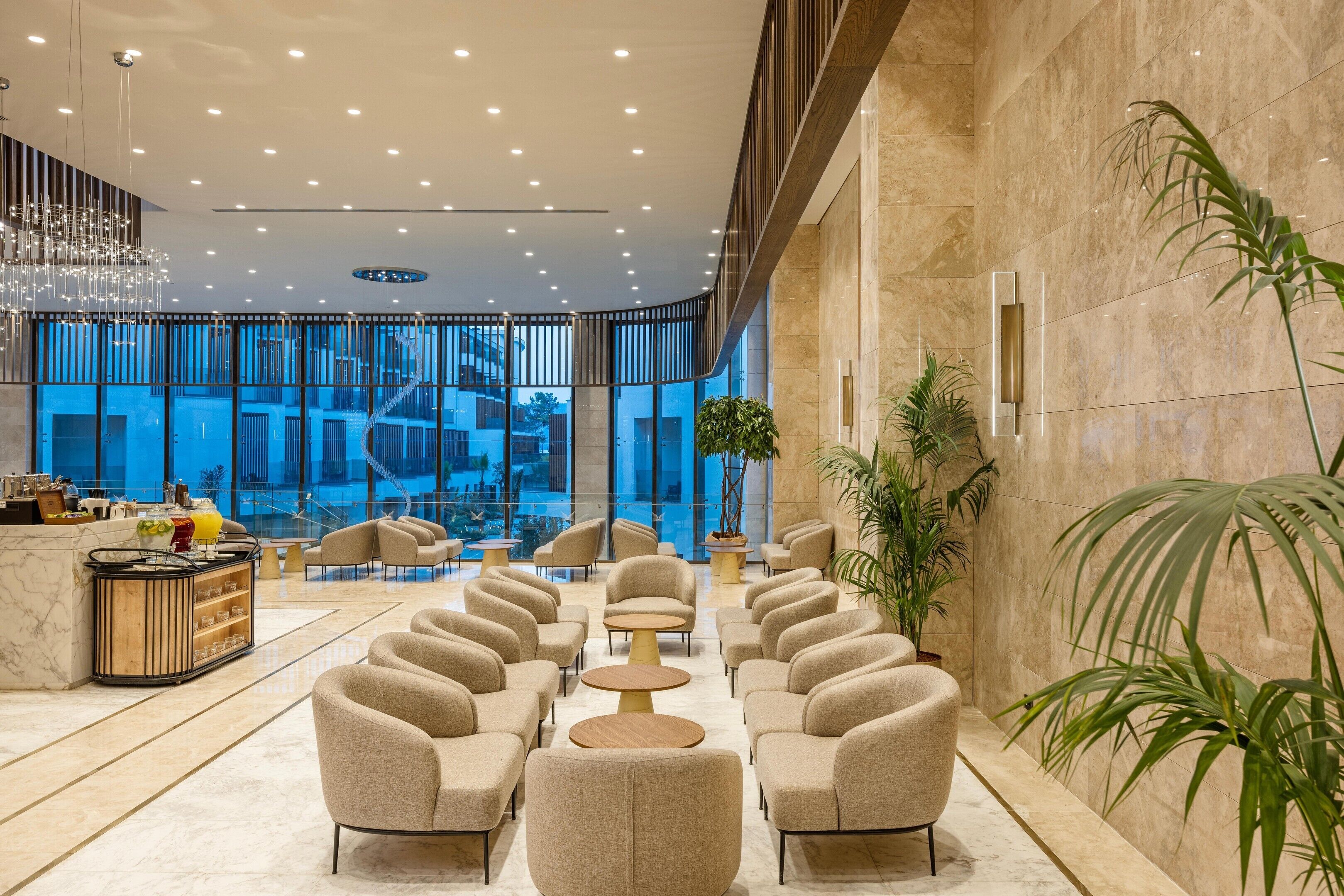 A modern lobby with seating, a reception desk, and a view of the outside.