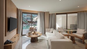 Une chambre d’hôtel moderne dotée d’une grande fenêtre, d’un téléviseur à écran plat, d’un canapé, d’une table basse et d’une table d’appoint en bois.