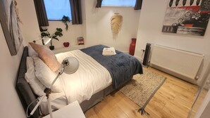Une chambre à coucher avec un lit, une lampe de chevet et un radiateur.