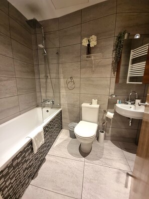 Un baño moderno con bañera, inodoro y lavamanos.