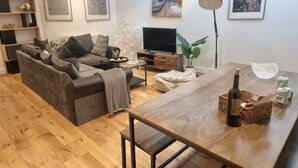 A modern living room with a sofa, coffee table, TV, and artwork on the walls. - Large Duplex 7 Adults at London Bridge (London)