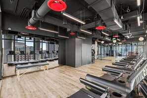 Ein Fitnessstudio mit Laufbändern, Bänken und Trainingsgeräten.
