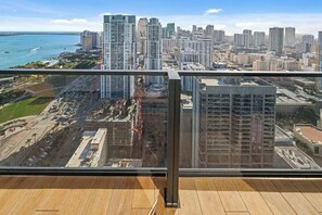 A high-rise building with a view of a cityscape, including tall buildings and a body of water.