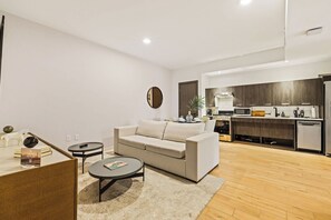 A modern living room with a sofa, coffee table, and a dining area with a table and chairs. - Bright Resort Style 1BR Heart of Miami Downtown (Miami)