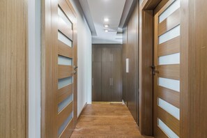 Un pasillo con puertas y piso de madera.