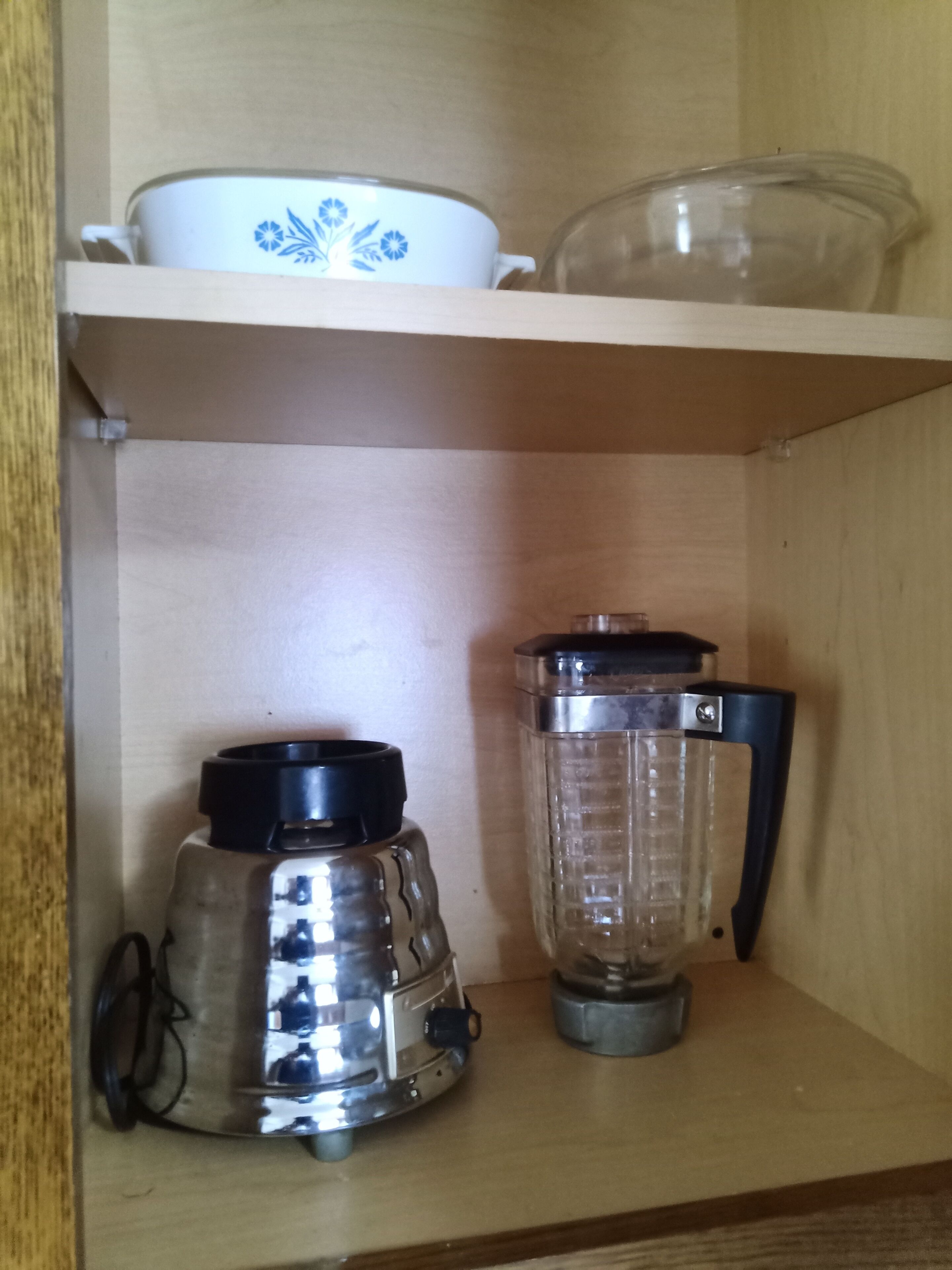 A wooden shelf with a coffee maker and a blender.