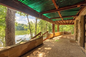 A covered outdoor area with a view of a lake, wooden benches, and a gravel path. - Wood Stove, Pool Table & Lake Dock (Goreville)