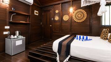 Une chambre d’hôtel équipée d’un lit, d’un mini-bar, d’un climatiseur fixé au mur et de panneaux décoratifs.
