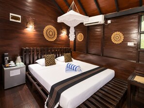 A hotel room with a bed, bedside table, and a window. - Coco Palm Villa and Cabanas (Tangalle)
