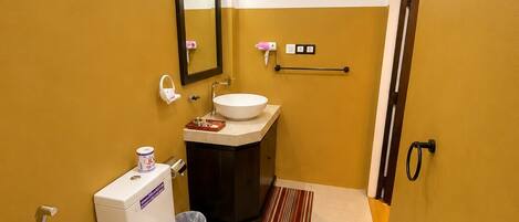 Un baño pequeño con inodoro, lavabo y espejo.