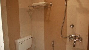A small bathroom with a toilet, bidet, and shower. - Hotel Aishwarya Inn (Jaipur)