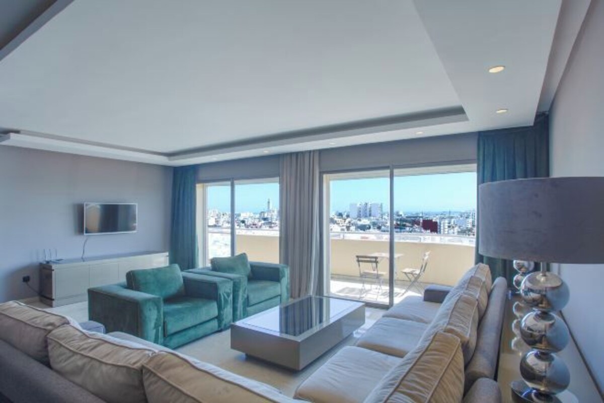 Una sala de estar moderna con un sofá, una mesa de centro y un televisor montado en la pared.