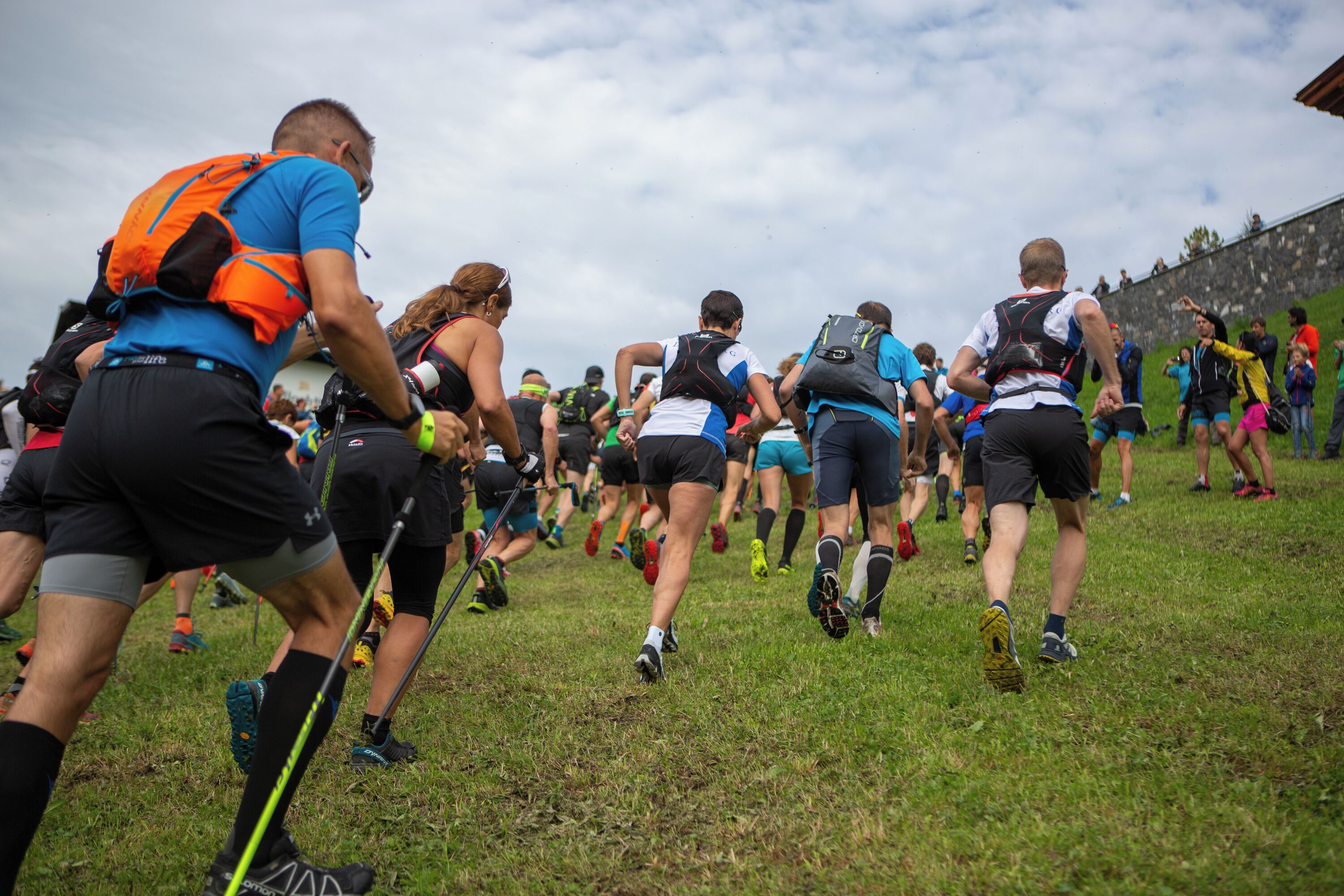 A group of people running on a grassy field.