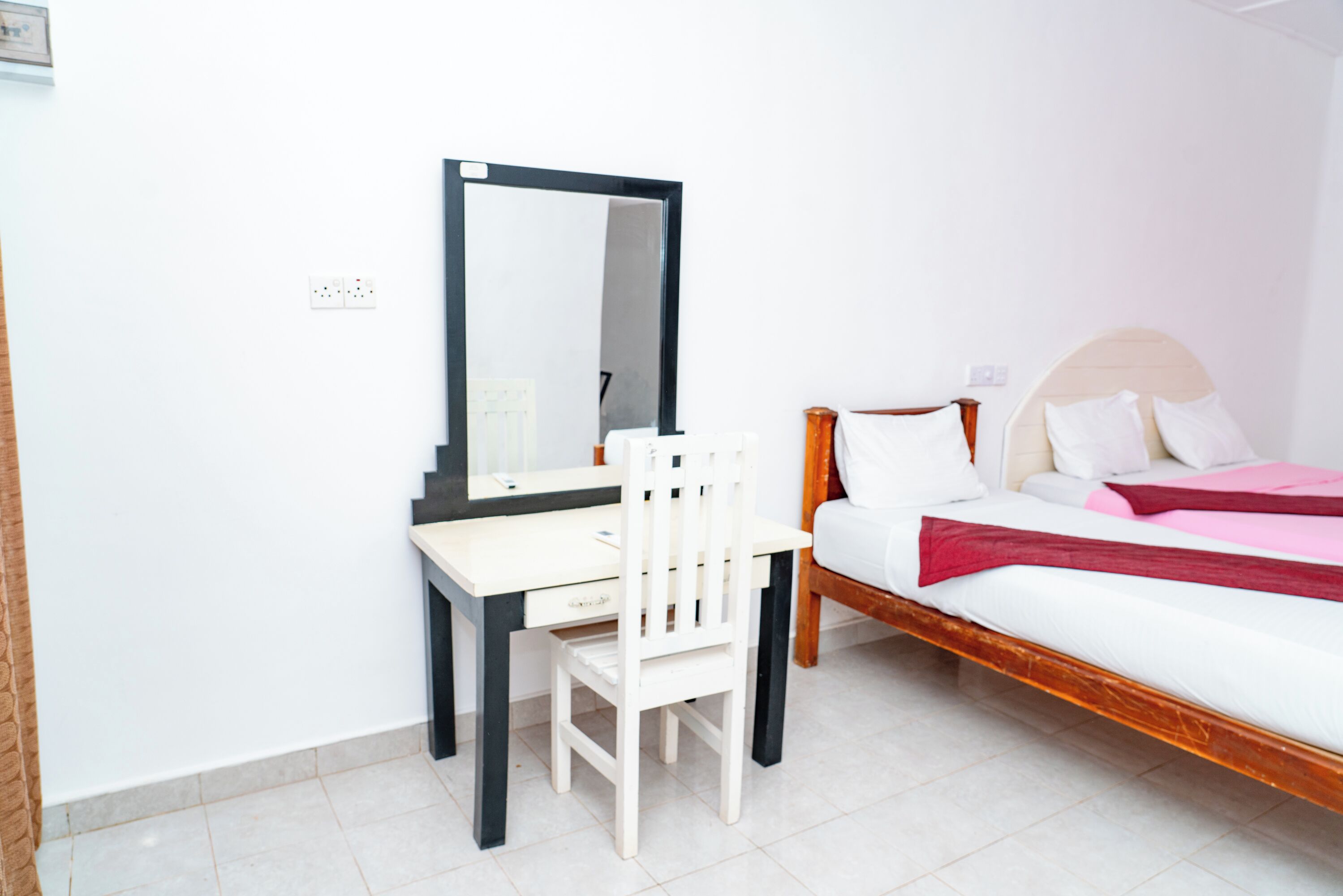 Een slaapkamer met een bed, een bureau en een stoel.