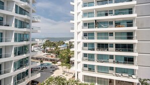 A multi-story hotel with balconies, a pool area, and a view of the sea. - w Comfy 2BR w Ocean View and Pool in CTG (Cartagena)
